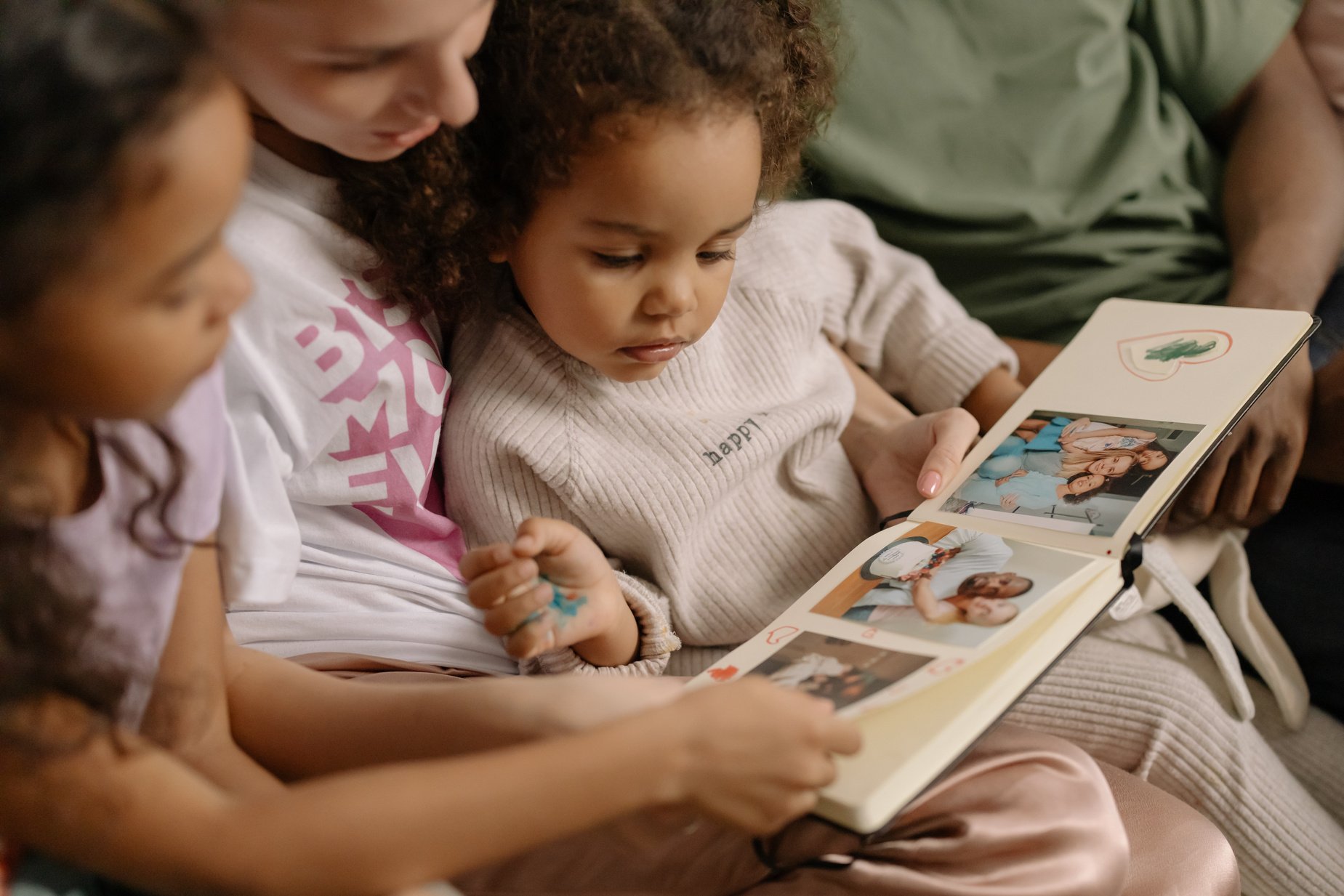 Mother with Daughters Looking at a Photo Album